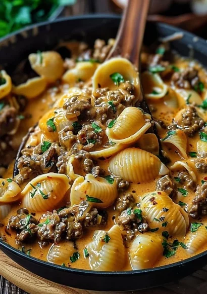Delicious creamy beef shells casserole topped with cheese and herbs