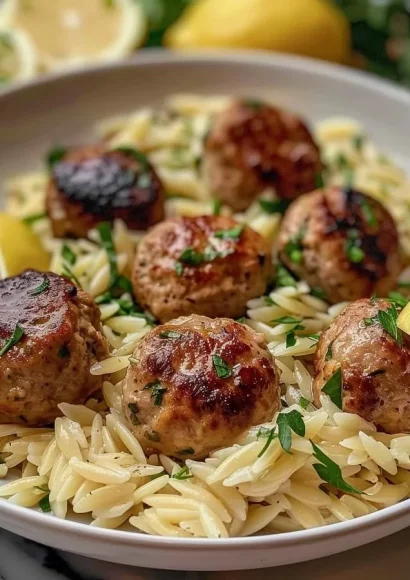 Plate of lemon chicken ricotta meatballs served with garlic orzo