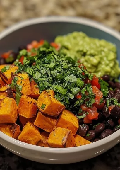 Sweet potato and black bean bowl topped with avocado lime dressing